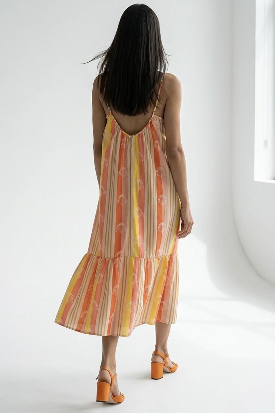 Vibrant striped maxi dress with fan motif and ruffle hem