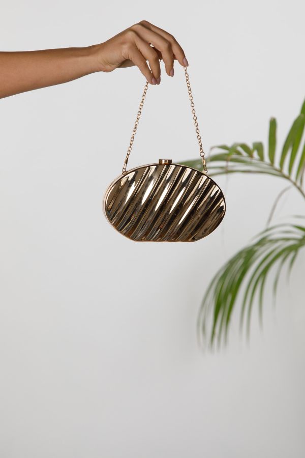 Metallic oval clutch with embossed stripes and chain strap